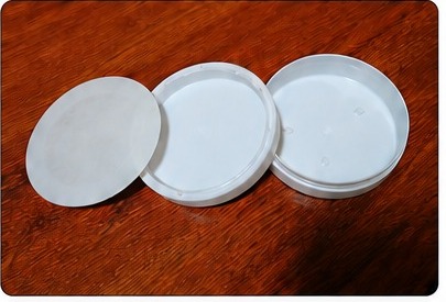 White 3-piece unhinged plastic nicotine pouch container shown open
